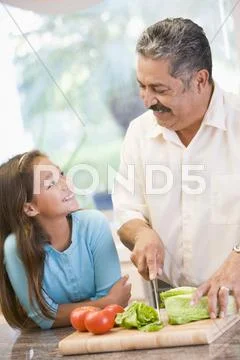 Grandfather and granddaughter preparing meal,mealtime together Stock Photos