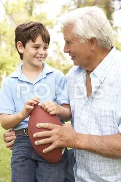 Grandfather and grandson playing american football together Stock Photos