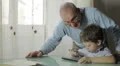 Grandfather and grandson using digital tablet together HD Footage