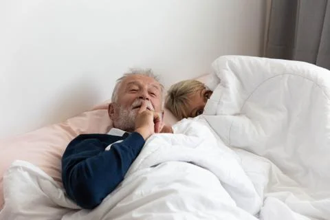 Grandfather ask to keep silence while grandmother is going to sleep Stock Photos