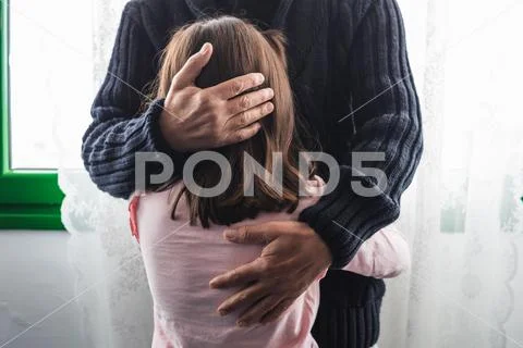 Grandfather comforts his crying granddaughter. Stock Photos