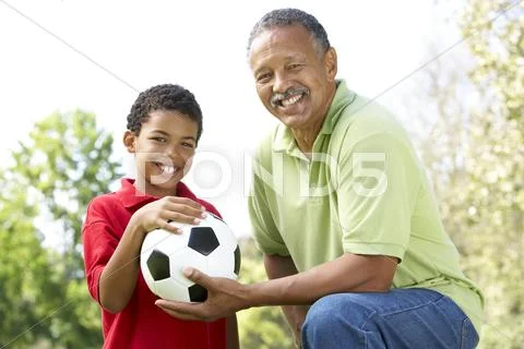 Grandfather With Grandson In Park With Football Stock Photos