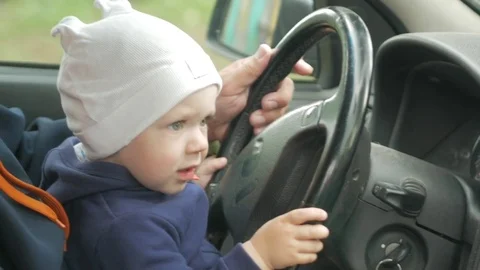 Grandfather plays with the boy in the car while driving. The grandson is very Stock Footage 76954562