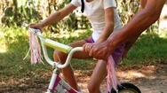 Grandfather Teaching His Granddaughter To Ride A Bike Stock Footage