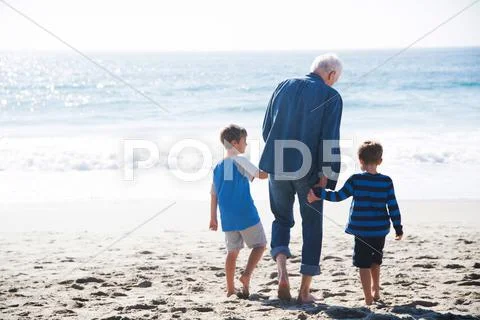 Grandfather With Two Grandsons, Walking On Beach, Rear View