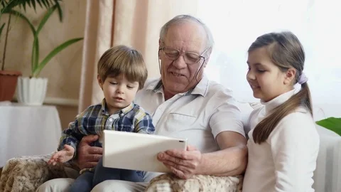 Grandfather using a tablet computer with grandchildren Stock Footage 84904606