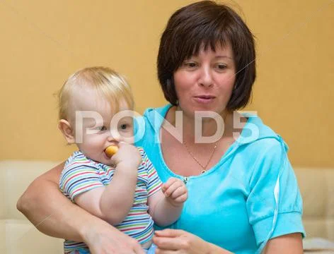 Grandma holds the newborn grandson Stock Photos