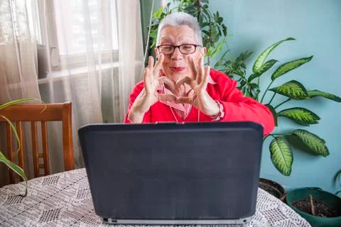 Grandma using laptop, camera and earphones for distant connections Stock Photos