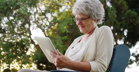 Grandma using tablet at the park Video stock 42724504