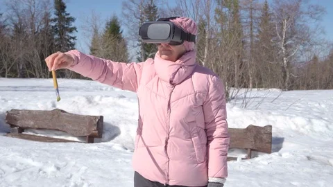 Grandma in virtual glasses is going to paint a picture. Woman in winter outdoors Stock Footage 117842874