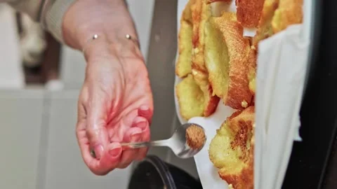 Grandmother adding brown panela sugar to fresh torrijas Stock Footage 264183284