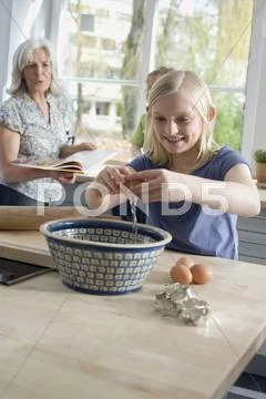 Grandmother and grandchildren (8-9) in the kitchen Stock Photos