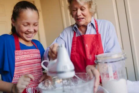 Grandmother and granddaughter baking in kitchen Stock Photos