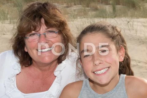 Grandmother and granddaughter embracing at the beach Stock Photos