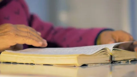 Grandmother eighty-three years old slowly turn the pages of the book. Stock Footage 84719236