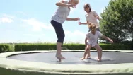 Grandmother, Granddaughter And Mother Bouncing On Trampoline Stock Footage