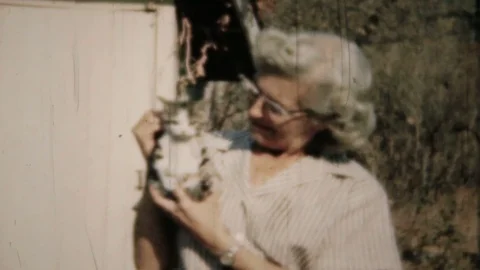 Grandmother holds one of her cats up to camera 1950s family home movie 5994 Stock Footage 126734035
