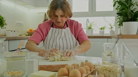 Grandmother is preparing dough in the kitchen. Selective focus. Stock Footage 170816320