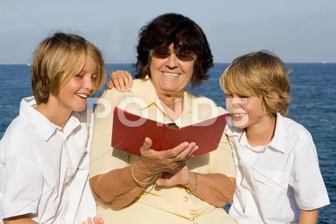 Grandmother, reading book to grandchildren Stock Photos