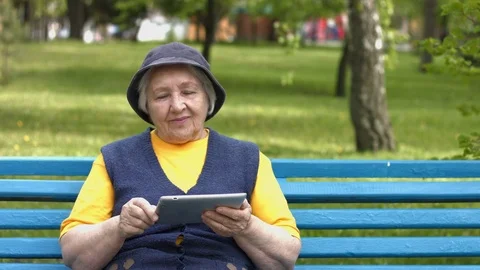 Grandmother uses a tablet computer. 2 Shots. Video stock 76016763