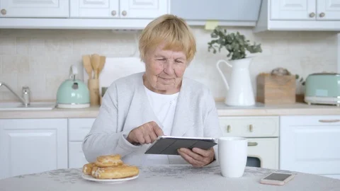 Grandmother Using Tablet Computer On Kitchen. Stock Footage 95149705