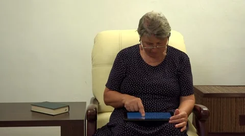 Grandmother using tablet, searching on internet network 4k Video stock 46215742