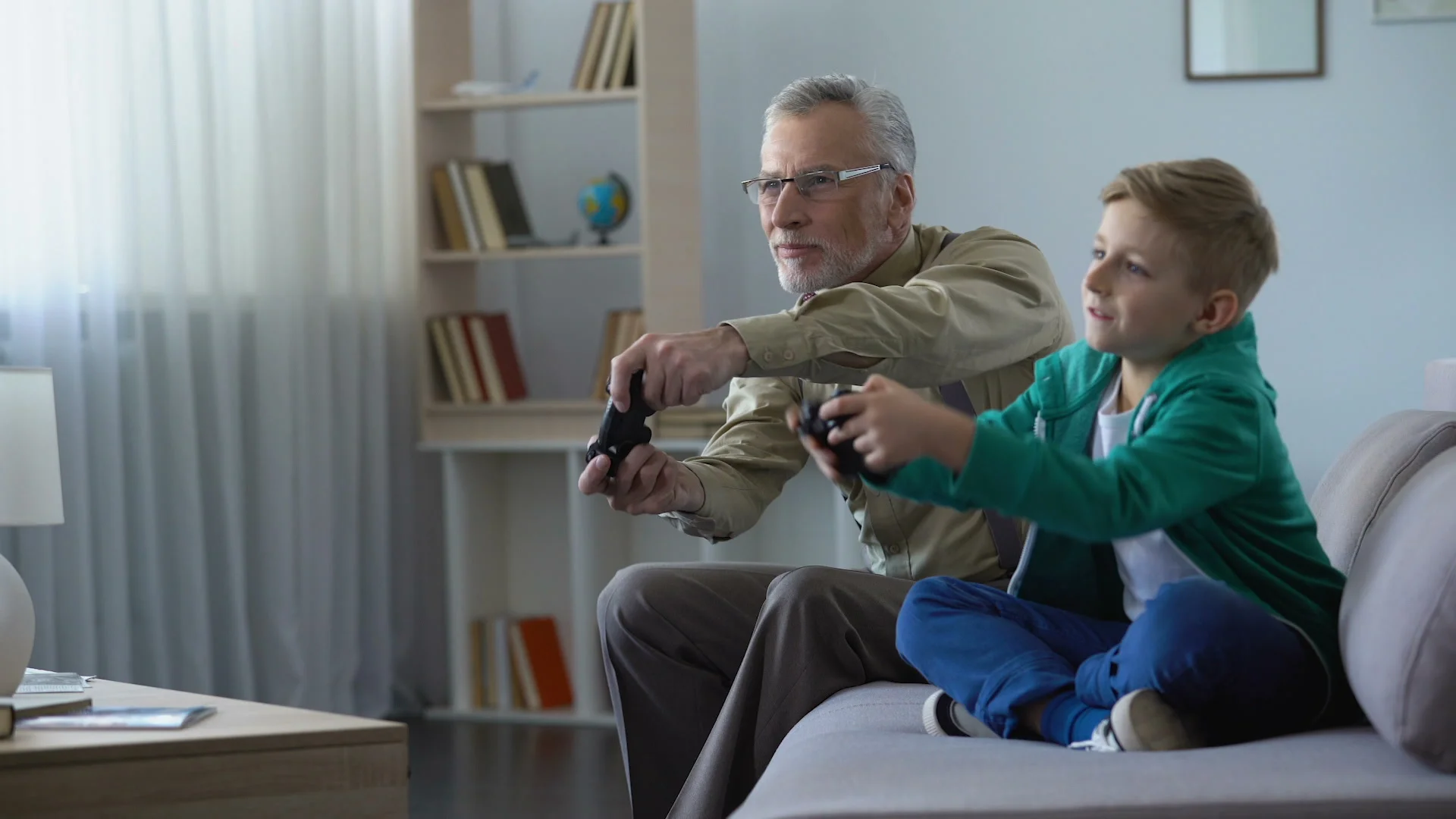 Grandpa playing video game with grandson, winning, communication with young