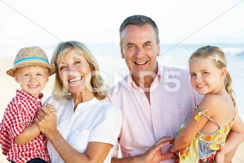 Grandparents and grandchildren enjoying beach holiday Stock Photos
