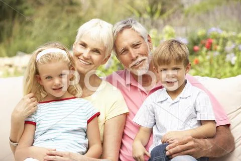 Grandparents And Grandchildren Relaxing In Garden Stock-Fotos