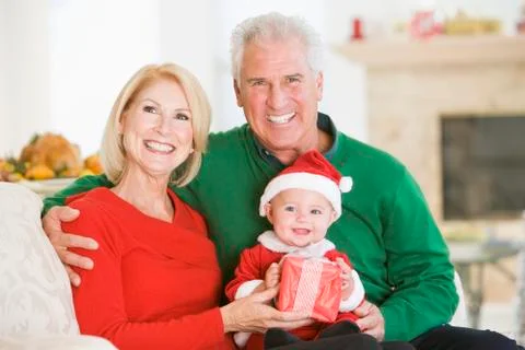 Grandparents With Baby In Santa Outfit Stock Photos
