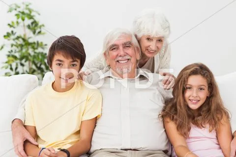 Grandparents with grandchildren on the sofa Stock Photos