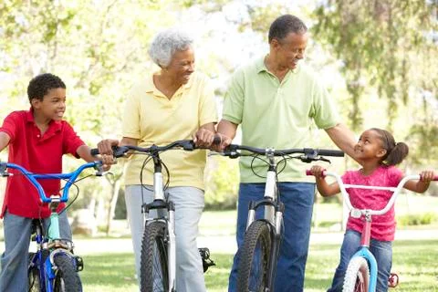 Grandparents In Park With Grandchildren Riding Bikes Stock Photos