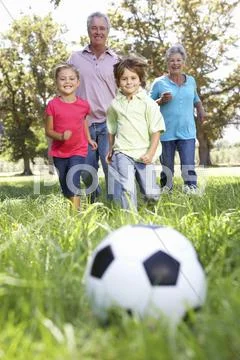 Grandparents playing football with grandchilderen Stock Photos