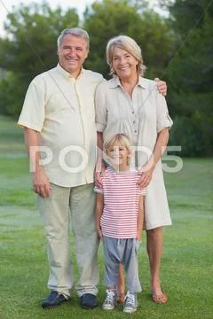 Grandparents standing with grandson Stock Photos
