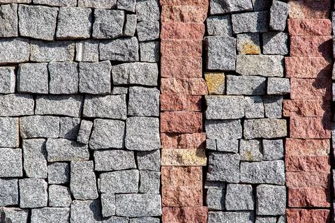Granite blocks of different sizes paved on the wall with a stone. 写真素材