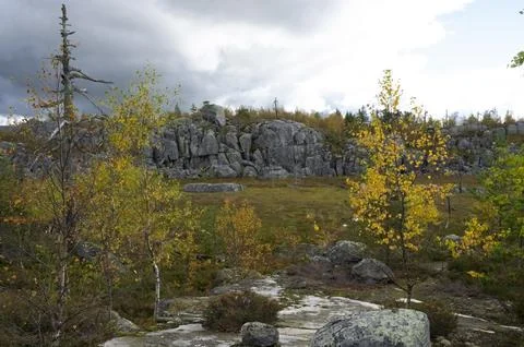 Granite cliff under a dark, dramatic sky. Stock Photos