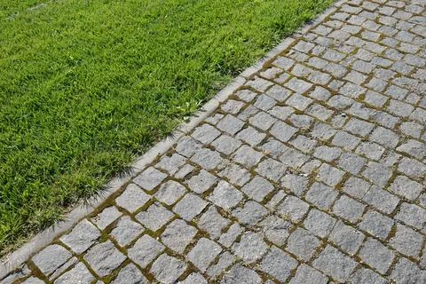 Granite cobblestone pathway border with green grass lawn high angle Foto stock