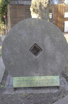 Granite millstone on display in Abbey Mills. Croydon, UK. Stock Photos