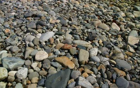 Granite pebbles, rounded by the ocean. Stock Photos