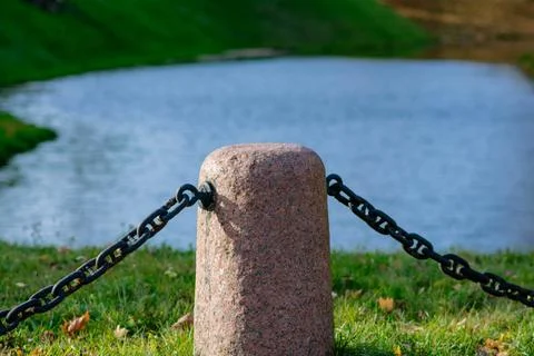 Granite posts with a large iron chain Stock-Fotos