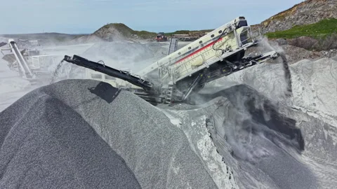 Granite quarry equipment processes stone at a mining site in daytime Stock Footage 340155836