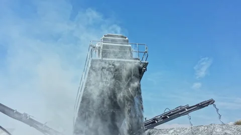 Granite quarry machine operates to crush and process stone material under clear Stockbeeldmateriaal 337911176