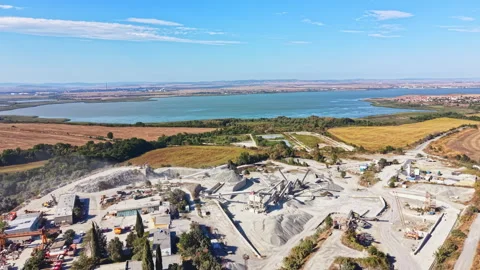 Granite quarry in an open landscape with water and fields in the background 動画素材 344798512