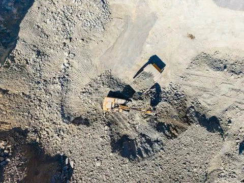 Granite quarry operation in progress with an excavator and dump truck at work Foto stock