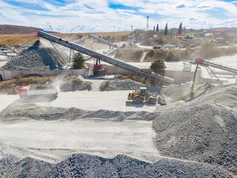 Granite quarry process with trucks and machinery working on site during the d Stock Photos