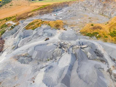 Granite quarry processes take place in an open environment with heavy machine Stock Photos