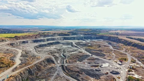 Granite quarry shows large open pit with machinery and trucks in action during Stock Footage 341080628