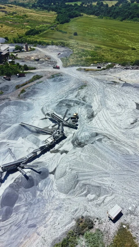 Granite quarry shows process of extraction and land use for mining near a green Stock Footage 337885519