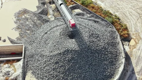 Granite quarry shows process of rock being crushed and piled by machinery in a Stock Footage 341090214