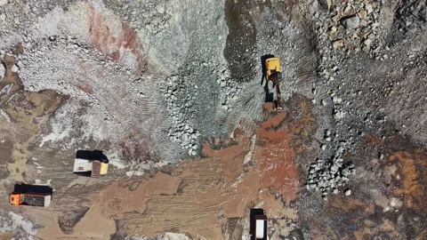 Granite quarry site with machinery working on stone extraction and trucks Stock Footage 339480284